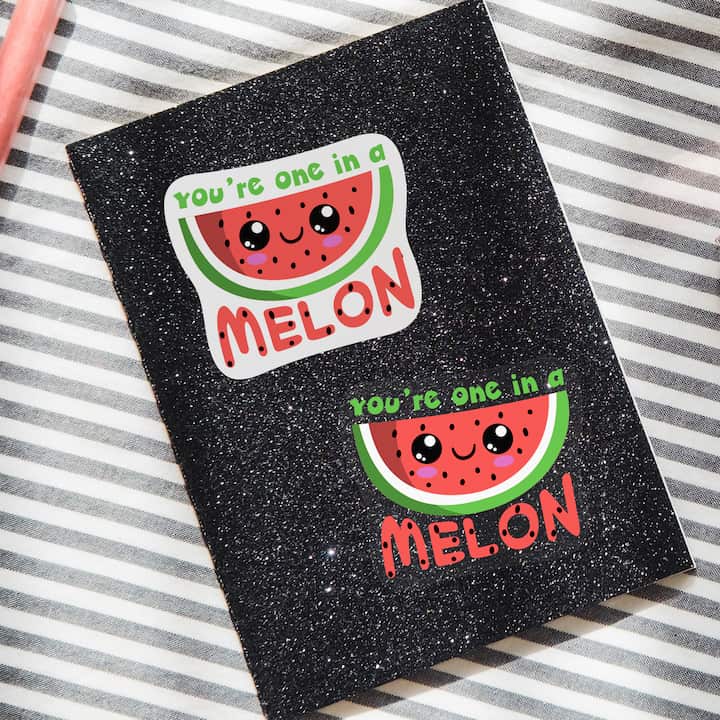 Comparison of a melon sticker using classic vinyl and clear sticker on a glitter folder.