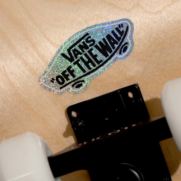 Vans 'Off The Wall' logo glitter sticker on a skateboard deck